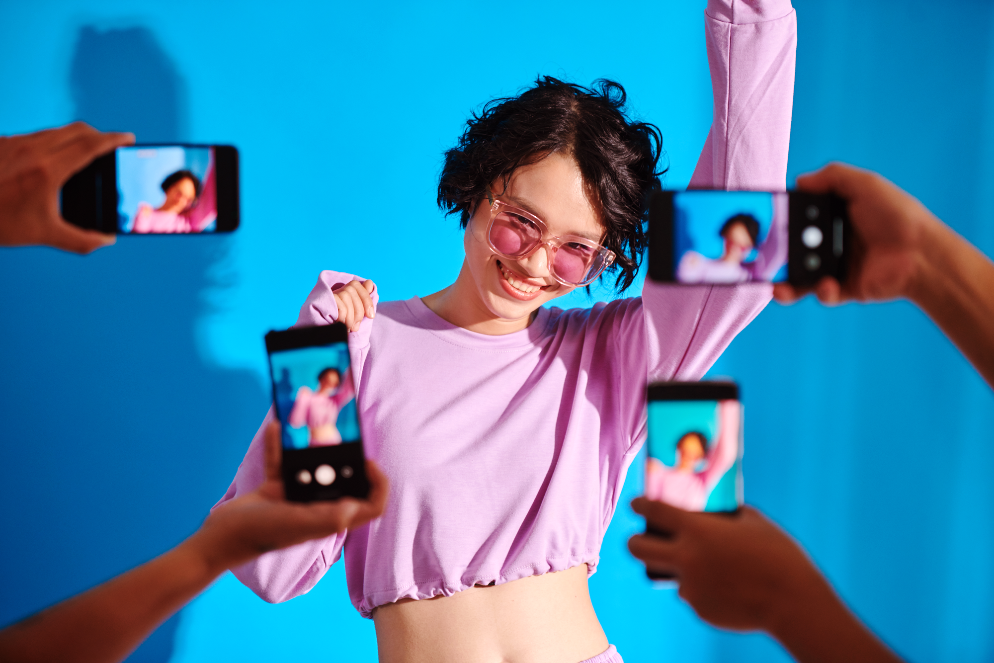 A female blogger being filmed from multiple phones